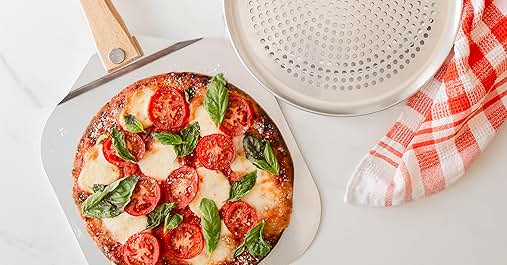a pizza sitting on top of a counter next to a pizza cutter.