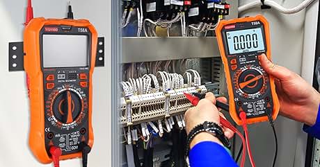 Dos multímetros digitales de color naranja: uno montado en un panel y otro sujetado a mano comprobando las conexiones eléctricas. Las pantallas del multímetro muestran «0000». Cableado y disyuntores visibles