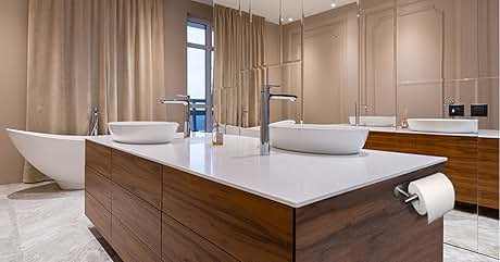 Baño moderno con tocador doble con gabinetes de madera, encimera blanca, dos lavabos y una bañera independiente. Combinación de colores neutros.