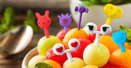 a bowl of fruit with plastic glasses on top