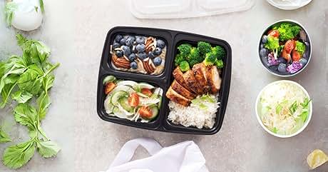 Meal prep containers with various foods: meat, vegetables, rice, and fruits. Fresh herbs visible in corner.