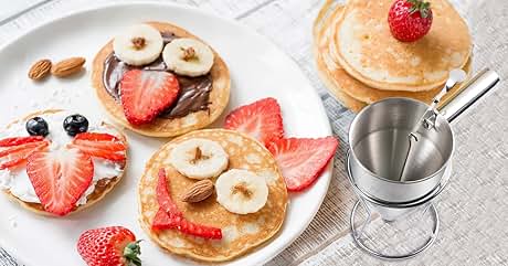 Assorted pancakes topped with strawberries, bananas, and nuts. Small stainless steel fondue pot visible in corner.