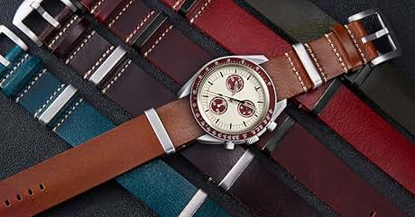 para hombre con correa de cuero marrón, esfera blanca y subesferas rojas. Se muestra en coloridas muestras de tela de color azul, rojo