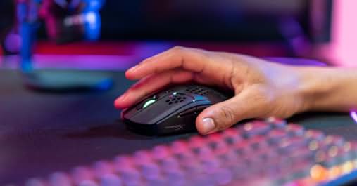 eine Hand, die eine Maus auf einer Tastatur