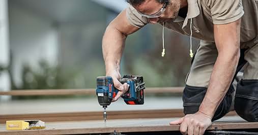 a man using a drill to cut wood
