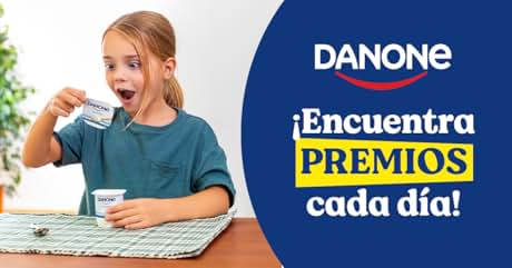 comiendo yogur en la mesa con la promoción de Danone visible. La pancarta azul dice «¡Encuentra PREMIOS cada día!» (¡Encuentra premios todos los días!).