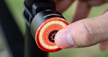 con pantalla LED circular roja brillante. Toca con el dedo la superficie de la luz, lo que demuestra la activación o la selección del modo. Luz montada en el cuadro de la bicicleta o en la tija del sillín