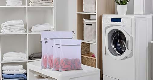 Laundry room with white washing machine, storage shelves, and mesh laundry bags in foreground. Clean, organized appearance.