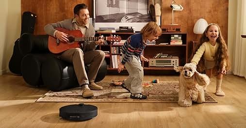 Living room scene with musical instruments, a dark robotic vacuum cleaner on hardwood flooring, and two small dogs.