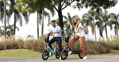 Dos personas montando bicicletas eléctricas plegables de color verde azulado en un sendero. Palmeras y césped en el fondo. El hombre viste camisa blanca y pantalones oscuros, la mujer viste pantalones cortos blancos y lleva una mochila.