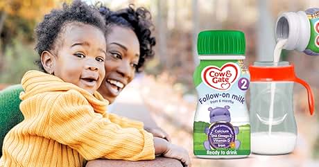 Cow & Gate follow-on milk bottle with green cap, alongside a clear baby bottle with orange handles.
