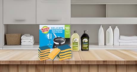 Assorted pet care products on wooden surface. Includes cat litter box, cleaning solutions, grooming tools, and towels. Kitchen cabinets visible in background.