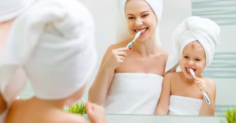madre e hija cepillándose los dientes en el baño