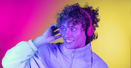 El texto dice «Imagen 1". Persona con auriculares morados y una chaqueta con cremallera de color claro, sonriendo y ajustándose los auriculares. Fondo colorido con degradado rosa y amarillo.