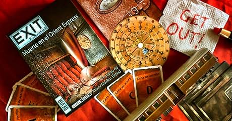 una mesa cubierta con un libro, un reloj, un libro y una brújula.