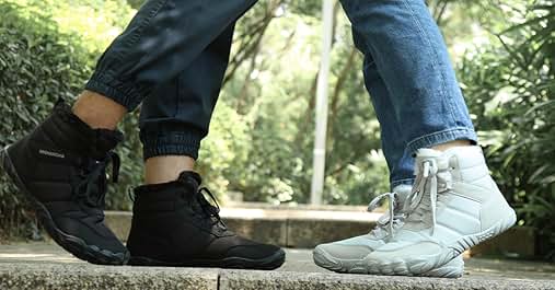 Primer plano de los pies de dos personas con zapatillas blancas y negras en contraste, de pie sobre una superficie de madera al aire libre