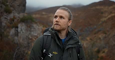 un hombre con cabello largo y una mochila mirando a lo lejos
