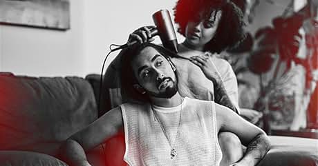 en uso para crear rizos u ondas. Imagen en blanco y negro teñida de rojo que muestra la funcionalidad del producto en el cabello de una persona