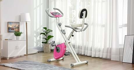 con pantalla digital, asiento ajustable y manillar. Diseño compacto adecuado para uso doméstico, colocado en una sala de estar luminosa