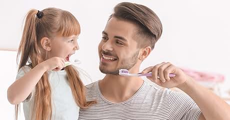 padre e hija cepillándose los dientes en el dormitorio