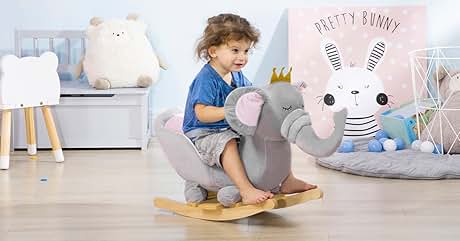 un niño pequeño montado en elefante en una mecedora de madera