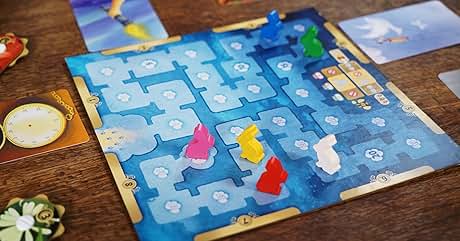 con área de juego con temática de hielo azul. Coloridas piezas con forma de pingüino en cuadrícula hexagonal. Cartas y fichas visibles en todo el tablero. El juego parece tratar sobre el movimiento de los pingüinos sobre el hielo