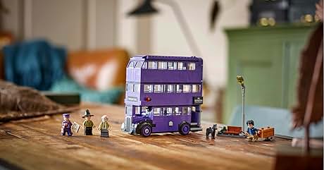 Expositor de autobús de juguete morado de tres pisos con figuras y accesorios en miniatura dispuestos sobre una superficie de madera, que muestra la construcción detallada