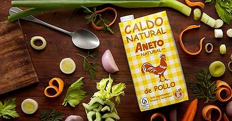 una caja de pollo y verduras sobre una mesa de madera.