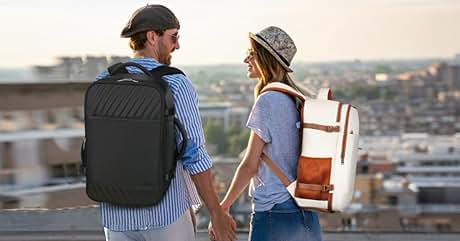 Dos personas con mochilas en una azotea. Una lleva una mochila negra con diseño acolchado, la otra una mochila blanca y marrón con detalles en cuero