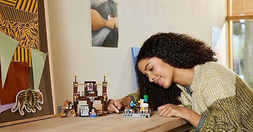 Expositor de maquetas arquitectónicas en miniatura con pequeños edificios detallados y elementos decorativos dispuestos sobre la superficie de una mesa.
