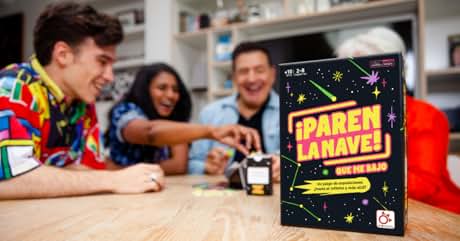 con temática espacial titulada «Paren La Nave!» en una mesa con gente reunida alrededor, aparentemente jugando