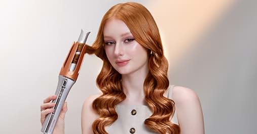 Woman with long, wavy red hair holding a silver and orange hair styling tool. The device appears to be a curling iron or hair waver with a unique design featuring two prongs.