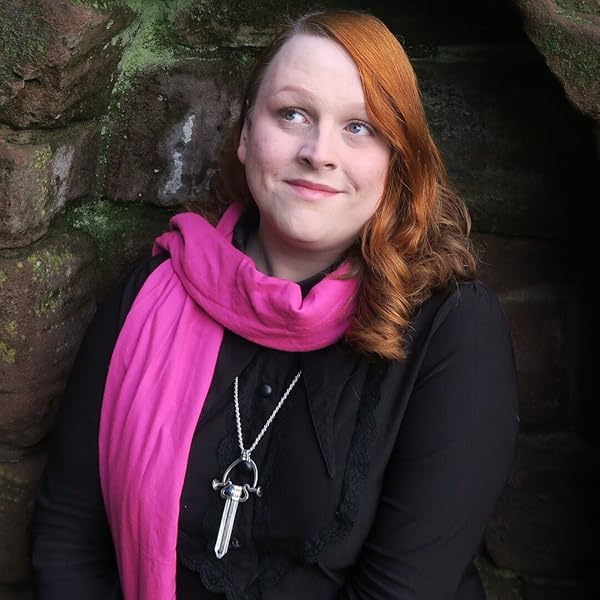 photograph of Mhara Starling with a pink scarf standing Infront of a stone wall