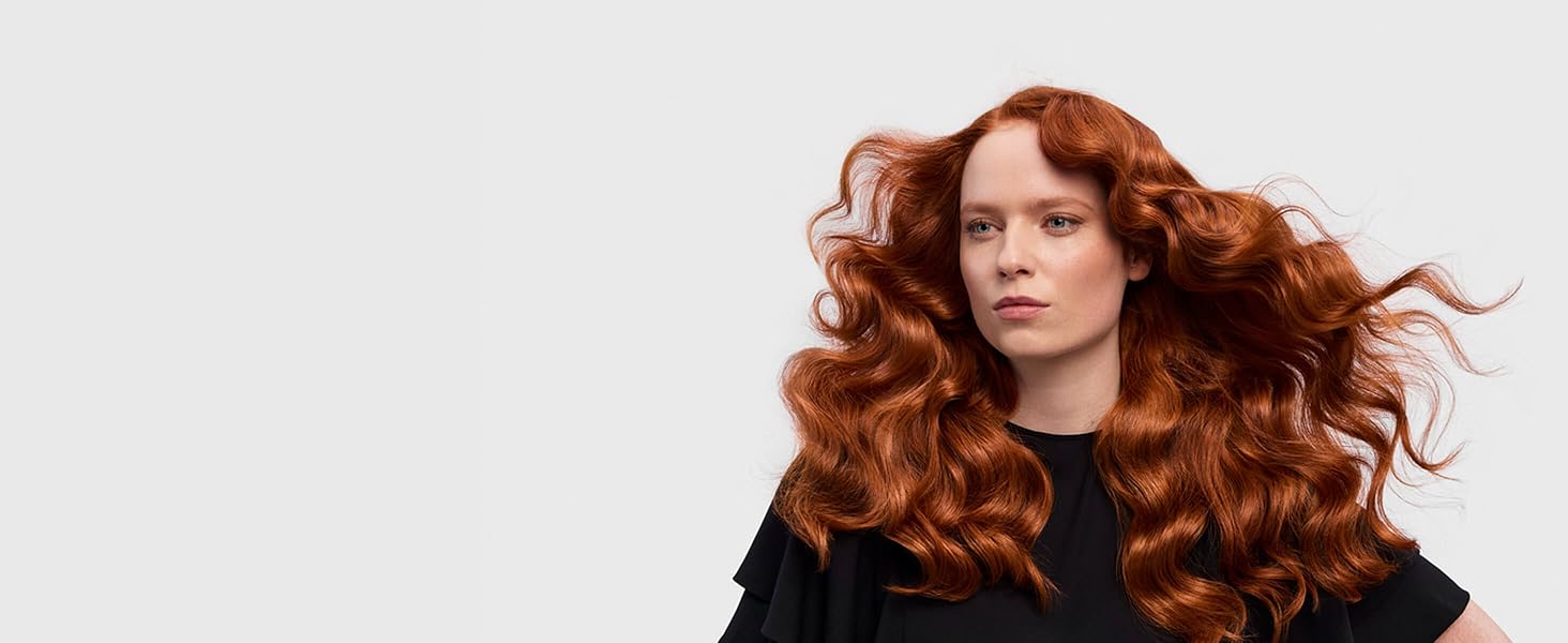 Ein rothaariges Model mit langen Haaren im Retro-Wellen-Style