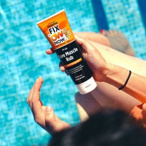 sore muscle rub on the pool deck by swimmer