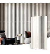 Vertical wood slat wall panels in light color. Room interior with dark chair, white sofa, and decorative elements against slatted wall backdrop.