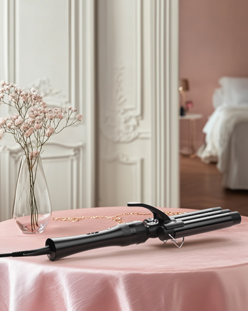 Fer à friser noir sur nappe rose. Cadre de porte blanc orné en arrière-plan avec chambre visible. Vase en verre orné de délicates fleurs roses.