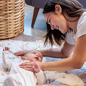 mom lovingly looking at baby on mat