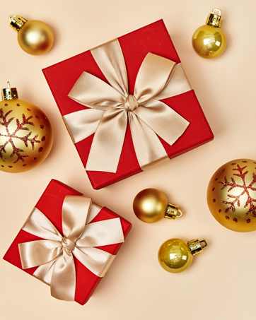 christmas gift boxes with gold ornaments on a beige background