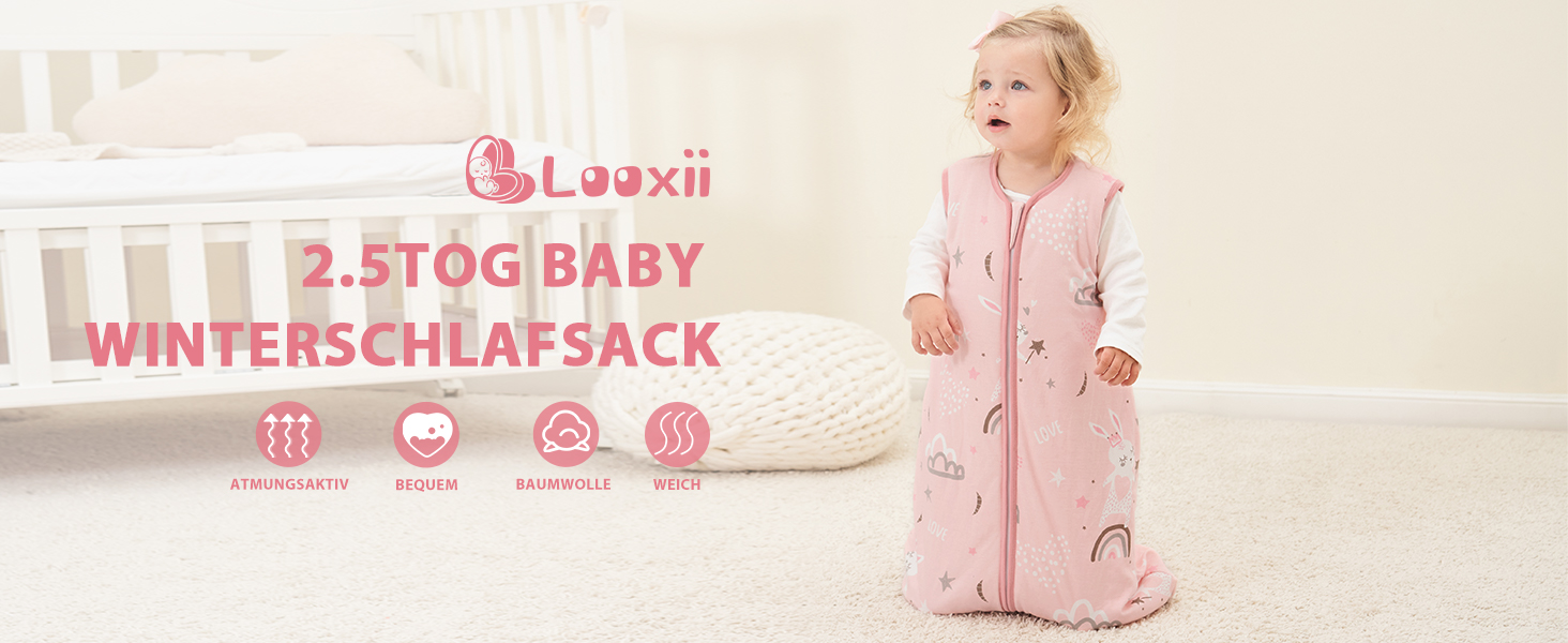 Rosafarbener Baby-Winterschlafsack mit Reißverschluss, der von einem Kleinkind getragen wird, das in einem Schlafzimmer steht. Zu den Produktmerkmalen gehört eine TOG-Bewertung von 2,5