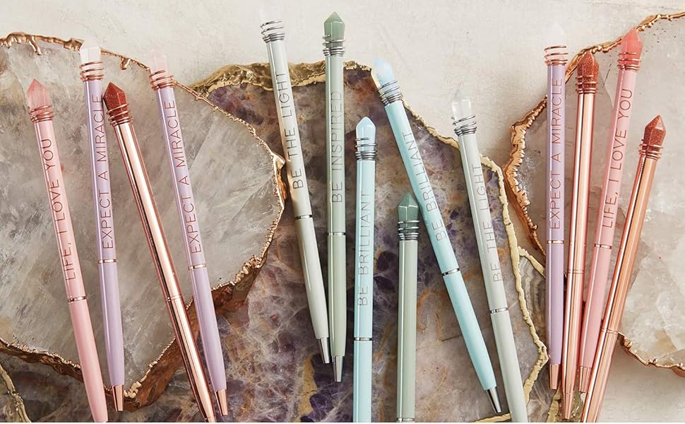 A rainbow spread of pens topped with gems set on top of stone discs