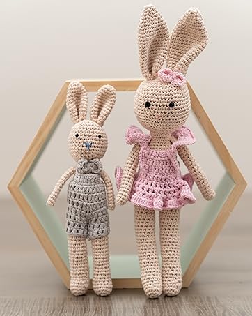 Hand crafted bunny son and mom dolls standing next to each other within beautiful backdrop scenery 