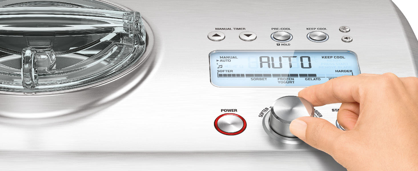 Top-loading washing machine control panel with digital display showing 'AUTO'. Hand adjusting a silver dial. Partial view of glass lid and metal drum visible.