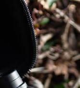 Close-up partial view of what appears to be a black textured surface or material with curved edge detail visible.