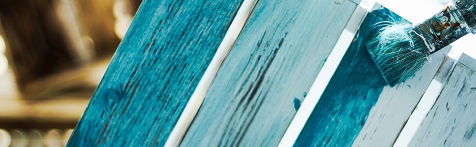 Nahaufnahme verwitterter Bücher mit abgenutzten Buchrücken in abwechselnden türkisfarbenen und weißen Farben, die ein klassisches oder antikes Aussehen mit strukturellen Details zeigen.
