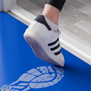 Sportlicher Schuh, der auf eine blaue Oberfläche tritt und einen Fußabdruck hinterlässt, der das Schuhsohlenmuster und die Griffigkeit des Schuhs demonstriert.