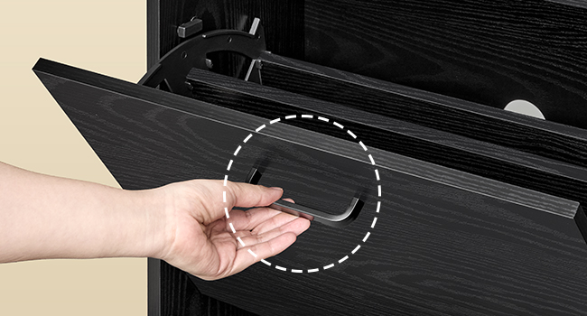 Ručné otváranie čiernej zásuvky alebo skrinky so zapustenou úchytkou. Biely bodkovaný kruh zvýrazňuje oblasť úchytky a ilustruje tak pohyb otvárania.