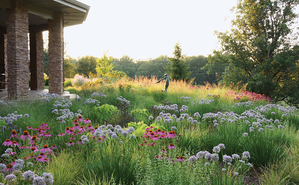 a statute in a lush prarie garden from beyond the garden