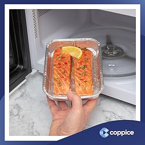 salmon steaks in foil tray being placed in microwave