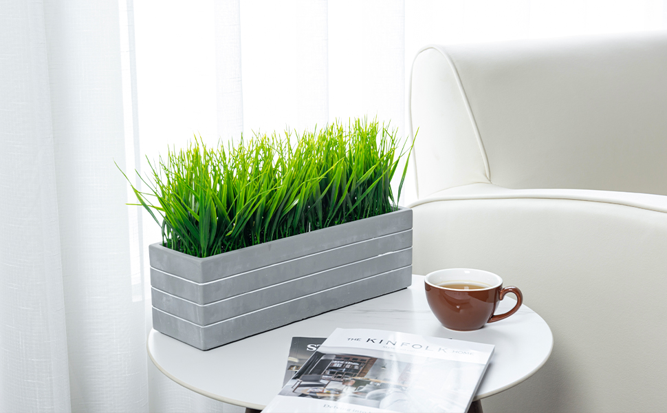 faux grass plant potted in cement planter